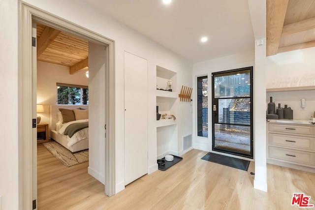 entryway with light hardwood / wood-style flooring, beamed ceiling, and wooden ceiling