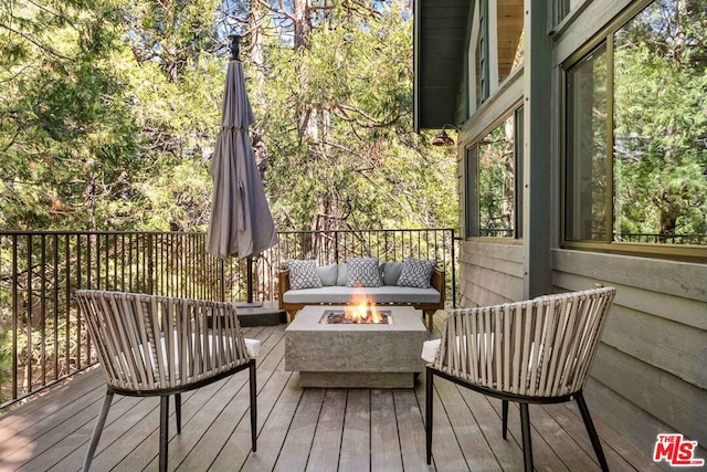 deck with an outdoor living space with a fire pit