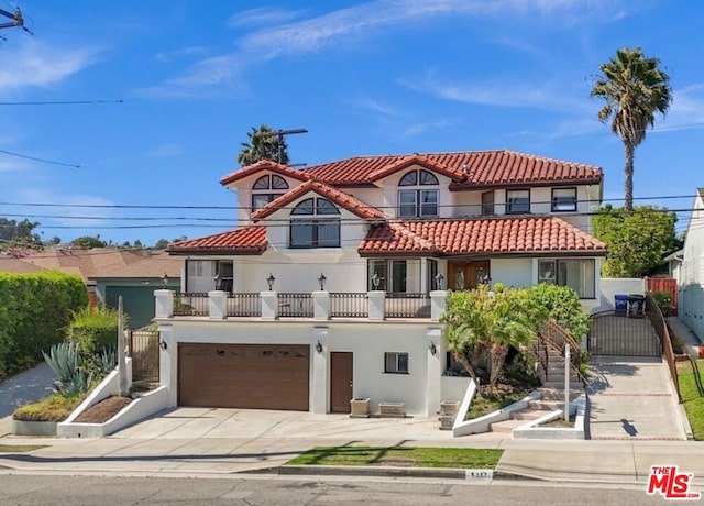 mediterranean / spanish home featuring a balcony and a garage