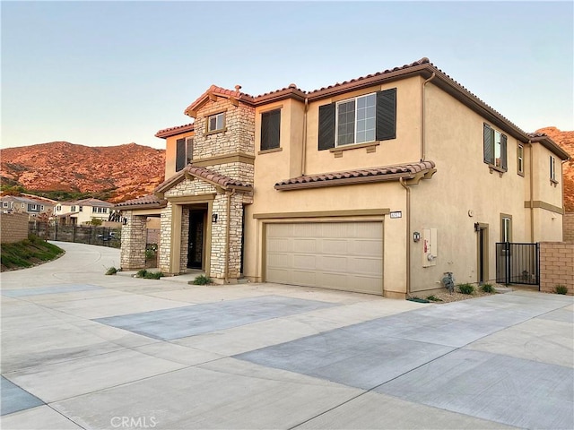 mediterranean / spanish-style house with a garage and a mountain view