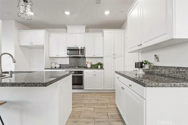 kitchen featuring white cabinetry, sink, stainless steel appliances, and light wood-type flooring