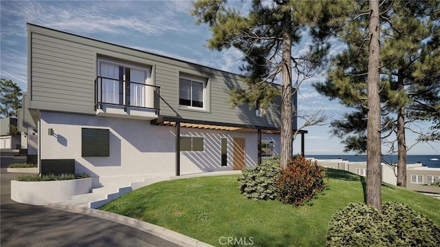 back of house featuring a yard and a water view