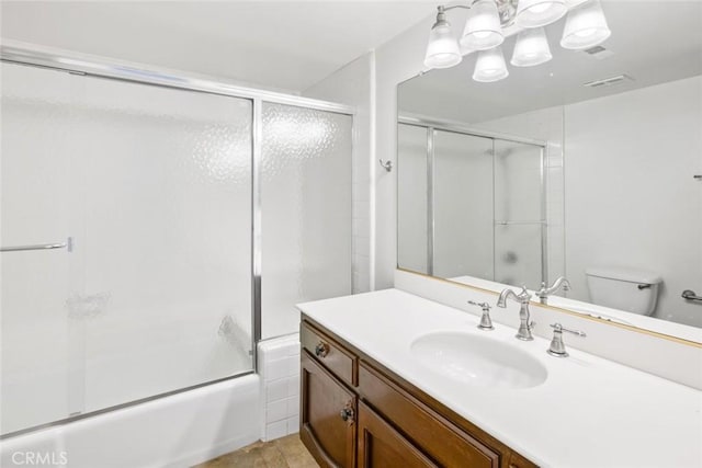 full bathroom featuring tile patterned floors, vanity, toilet, and shower / bath combination with glass door