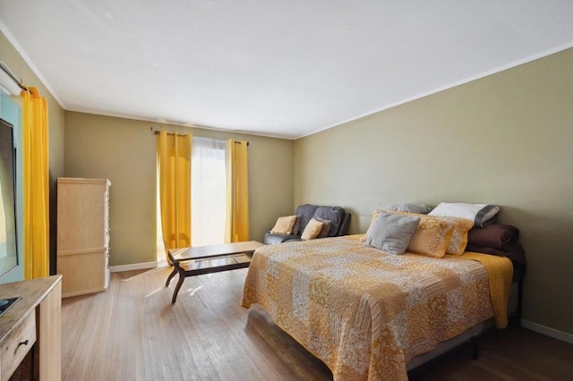 bedroom with wood-type flooring and ornamental molding