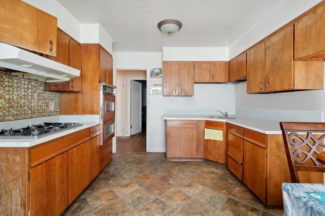 kitchen with decorative backsplash, sink, and stainless steel appliances