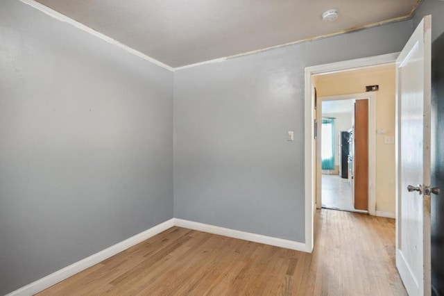 unfurnished room with light hardwood / wood-style flooring and crown molding