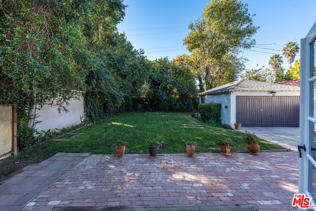 view of yard with a patio area, an outdoor structure, and a garage