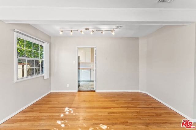 spare room with light hardwood / wood-style floors and track lighting