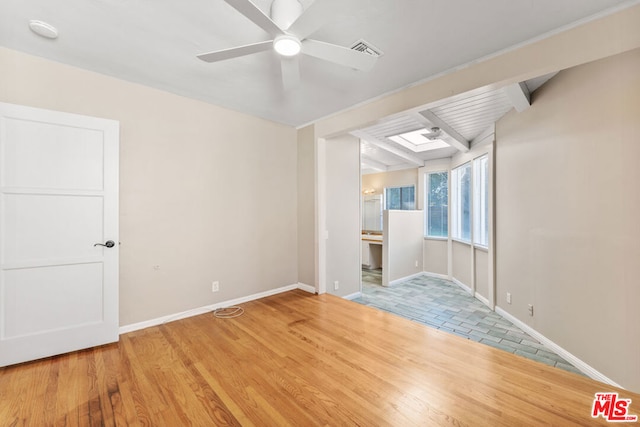 unfurnished room featuring beam ceiling, ceiling fan, and wood-type flooring