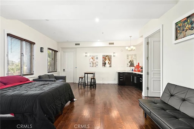 bedroom with dark hardwood / wood-style floors and a notable chandelier