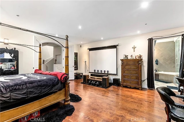 bedroom with wood-type flooring and ensuite bath