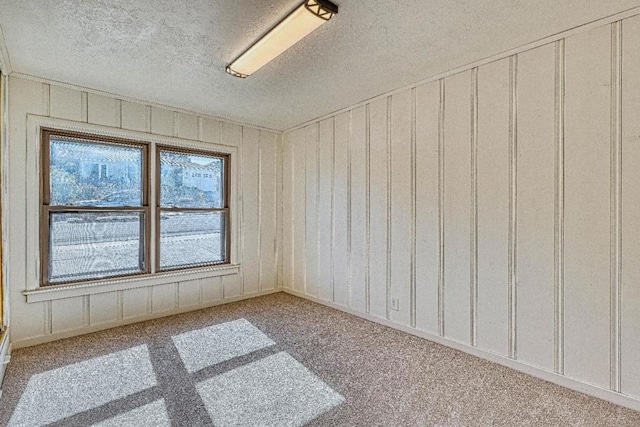 carpeted empty room with a textured ceiling