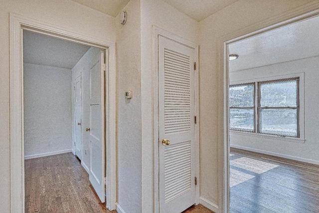 corridor with hardwood / wood-style flooring