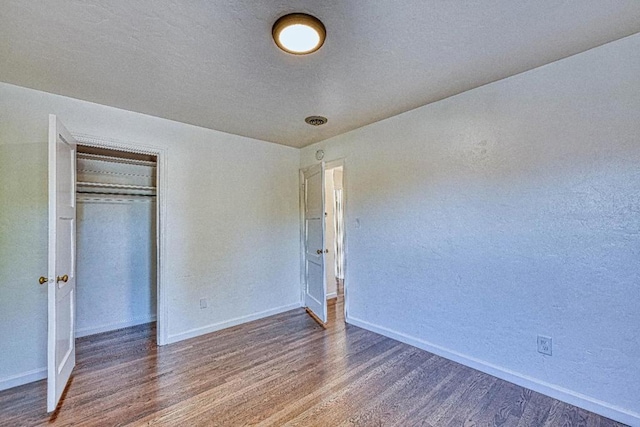 unfurnished bedroom featuring dark wood-type flooring and a closet