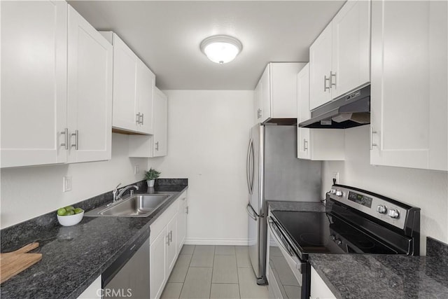 kitchen featuring white cabinets, appliances with stainless steel finishes, dark stone countertops, and sink