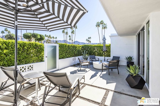 view of patio featuring a mountain view and an outdoor living space with a fire pit