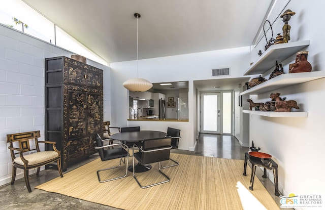 dining space with concrete flooring, sink, and french doors