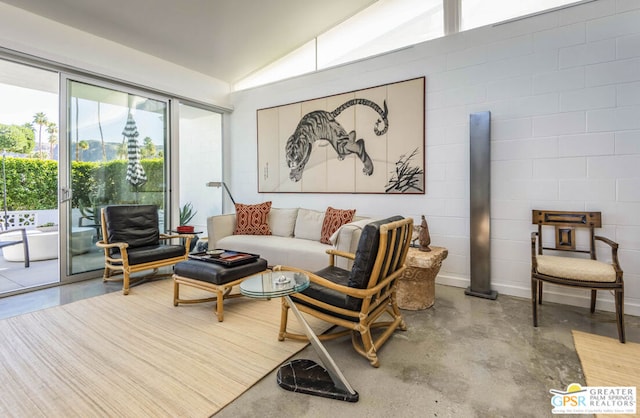 living room featuring concrete floors and vaulted ceiling