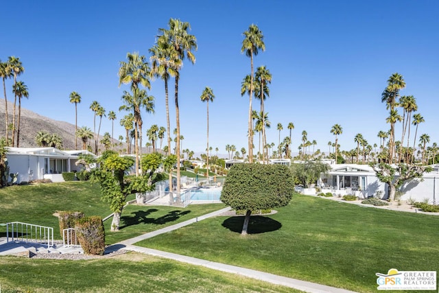 view of home's community featuring a mountain view, a pool, and a lawn