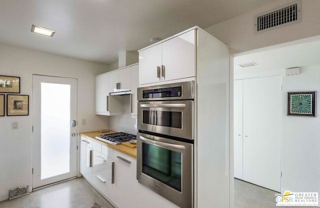 kitchen featuring white cabinets, appliances with stainless steel finishes, and tasteful backsplash