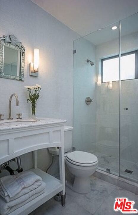 bathroom with vanity, toilet, and a shower with shower door