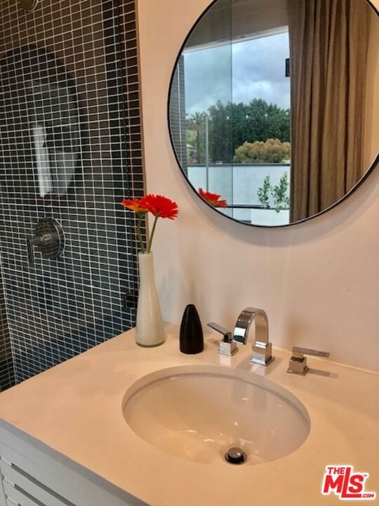 bathroom with a tile shower and sink