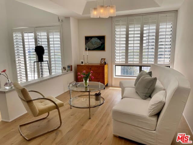 sitting room with an inviting chandelier, light hardwood / wood-style flooring, and a healthy amount of sunlight