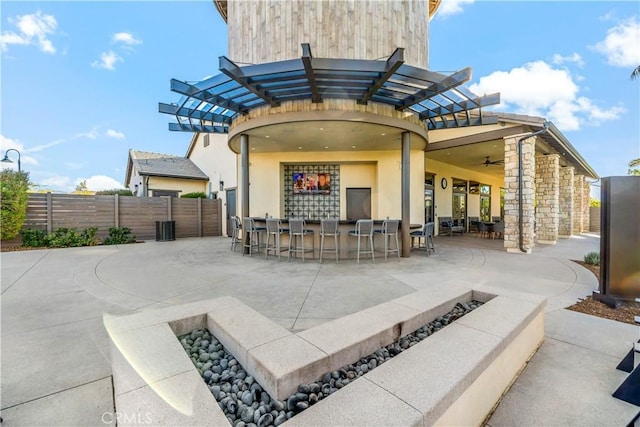 view of patio featuring ceiling fan and an outdoor bar