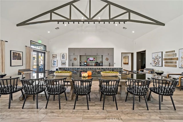 dining space featuring high vaulted ceiling