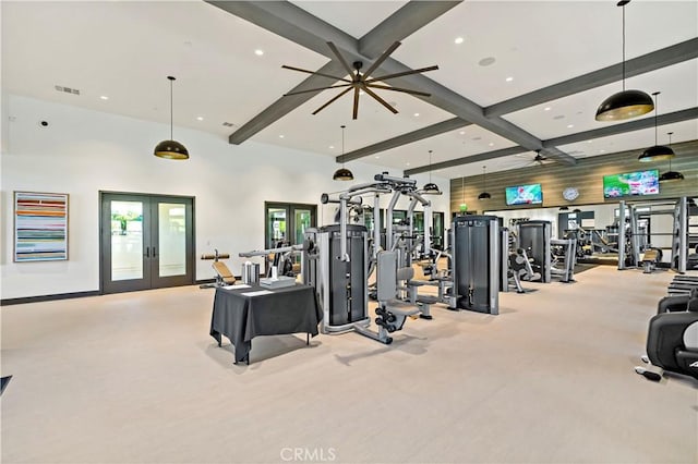 exercise room featuring french doors, a towering ceiling, and ceiling fan