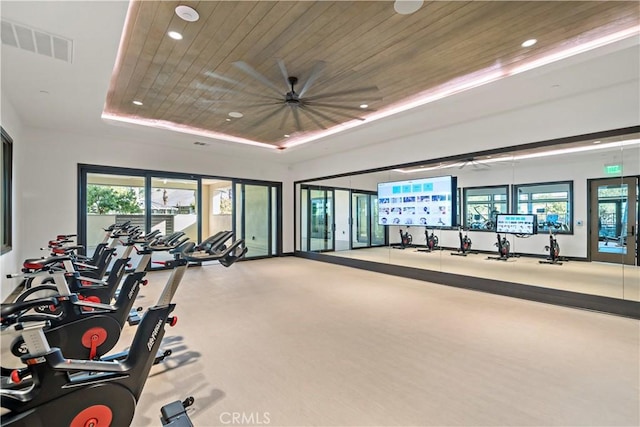 exercise room with a raised ceiling and wooden ceiling