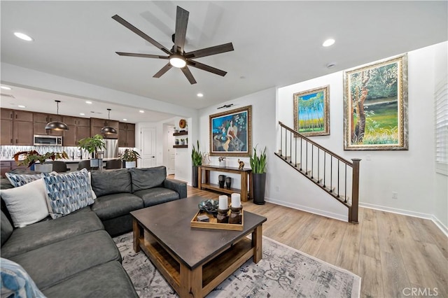 living room with light hardwood / wood-style floors and ceiling fan