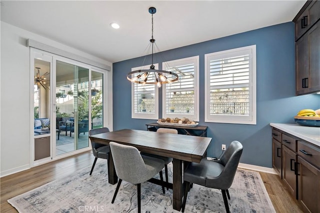 dining room with light hardwood / wood-style flooring and a notable chandelier