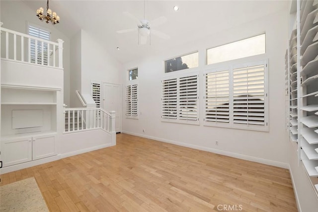 unfurnished living room featuring light hardwood / wood-style flooring, high vaulted ceiling, and a healthy amount of sunlight