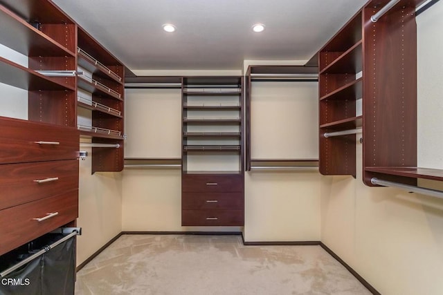 walk in closet featuring light carpet