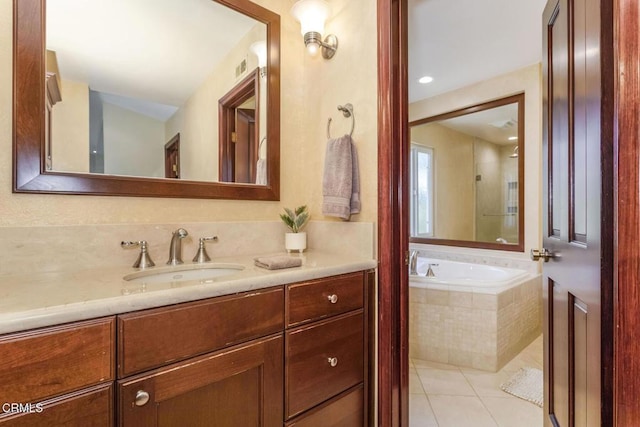 bathroom with vanity, a relaxing tiled tub, and tile patterned floors