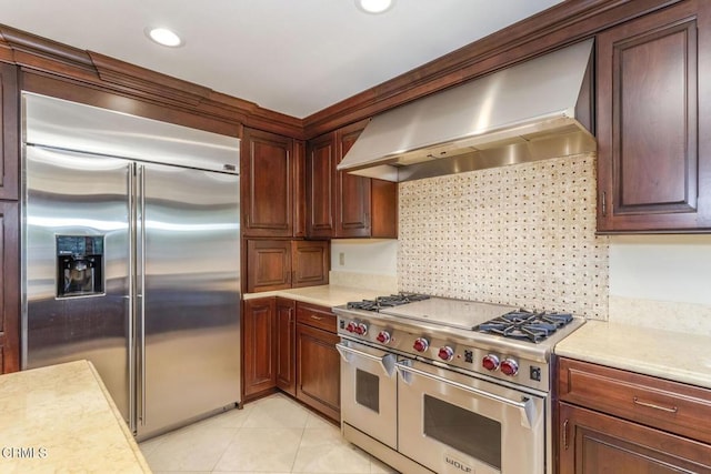 kitchen featuring high quality appliances, ventilation hood, light tile patterned floors, and backsplash