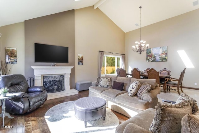 living room with high vaulted ceiling, a high end fireplace, hardwood / wood-style floors, and an inviting chandelier