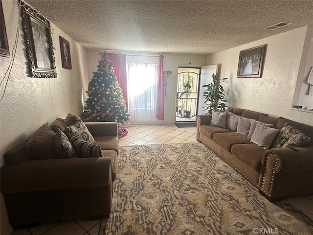 tiled living room featuring a textured ceiling