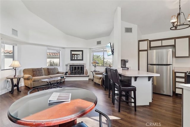 living room featuring vaulted ceiling, dark wood-type flooring, and a chandelier