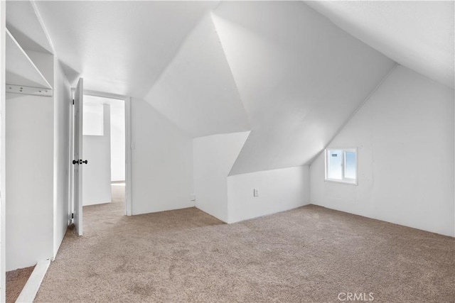 additional living space with light carpet and lofted ceiling