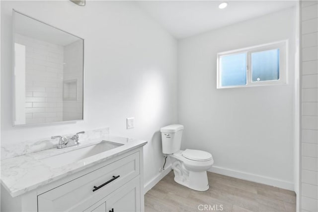 bathroom with hardwood / wood-style flooring, vanity, and toilet