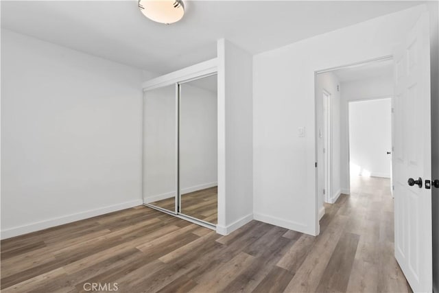 unfurnished bedroom featuring hardwood / wood-style floors and a closet