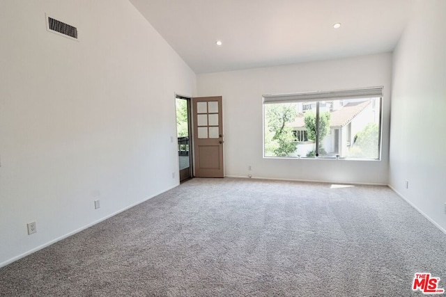 carpeted empty room featuring high vaulted ceiling