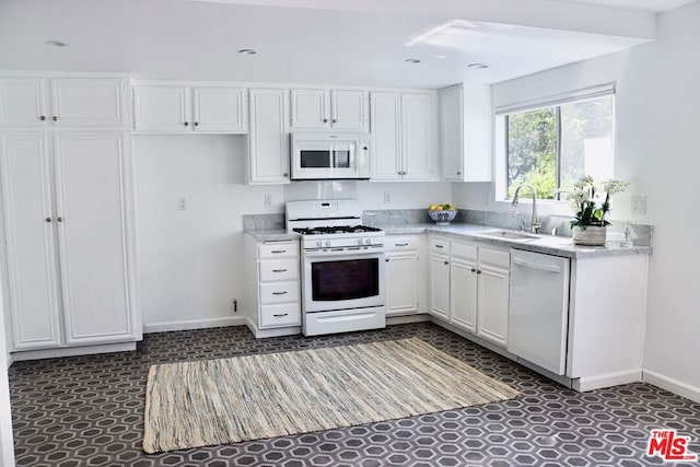 kitchen with white cabinetry, white appliances, and sink