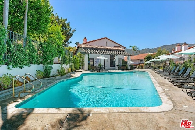 view of swimming pool with a mountain view and a patio