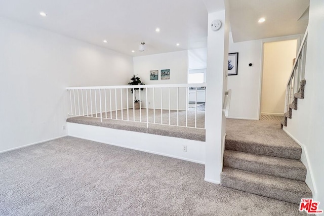 staircase featuring carpet