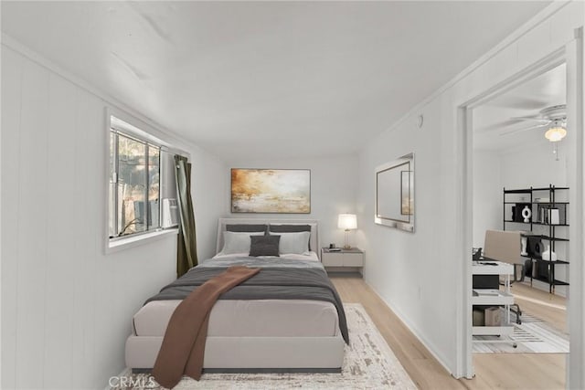 bedroom with light hardwood / wood-style flooring, ceiling fan, and crown molding