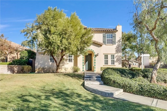 mediterranean / spanish house featuring a front lawn