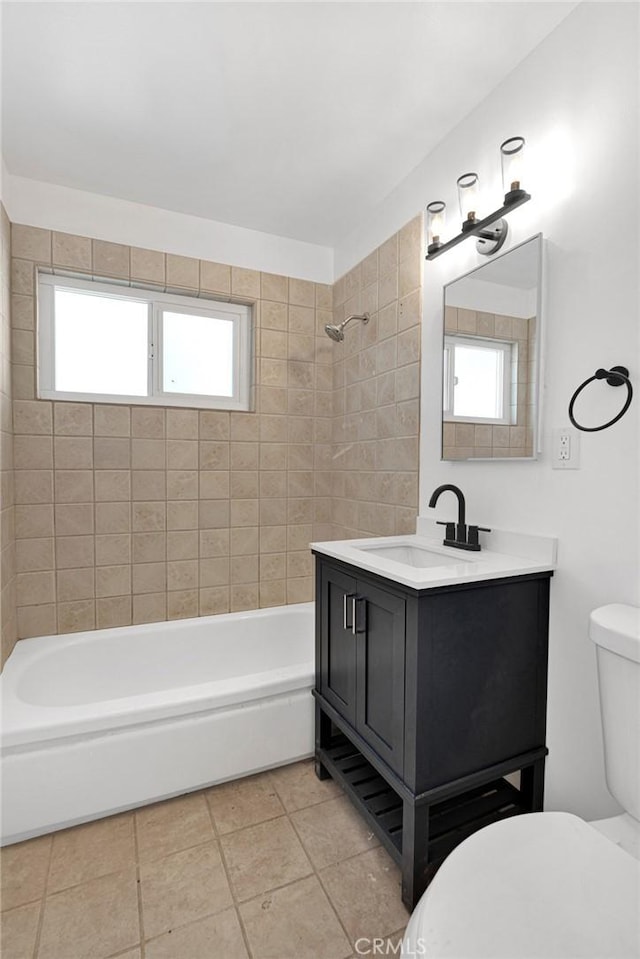 full bathroom featuring tile patterned floors, vanity, toilet, and tiled shower / bath